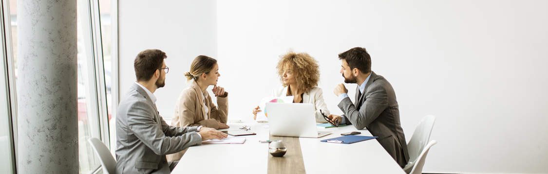 4 people having a meeting at a long table